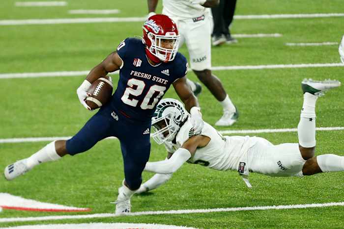 Fresno State running back Ronnie Rivers (20) breaks through the grips of Colorado State defensive back Keevan Bailey (25) in the Bulldogs' 38-17 win over Colorado State on Oct. 29, 2020.